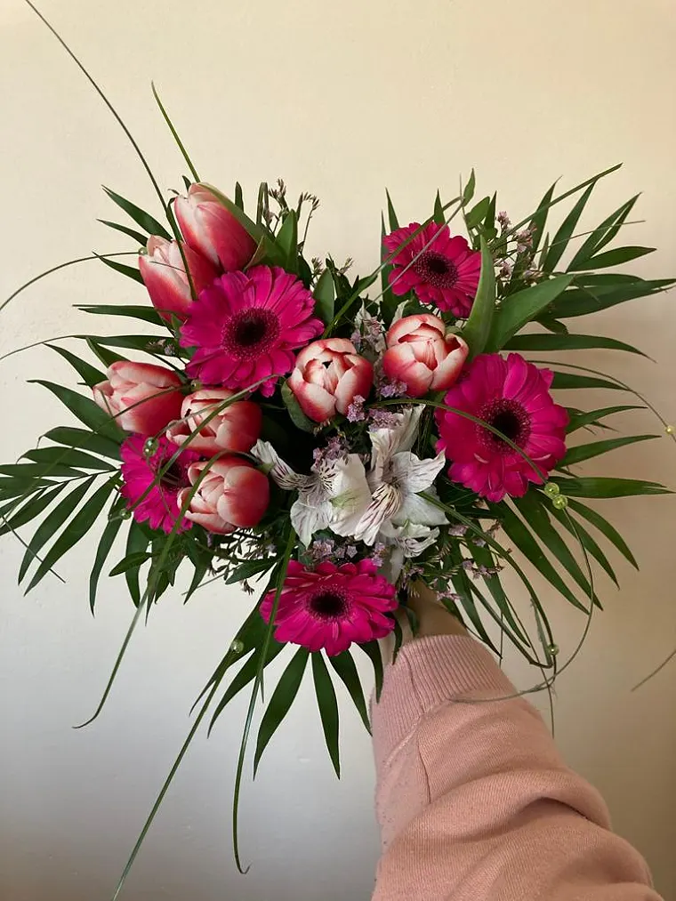 Kytice z tulipánů a gerber v ruce floristky